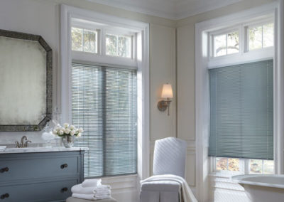 gray aluminum blinds on bathroom windows with blue and white accents