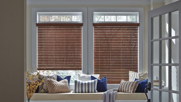brown faux wood blinds on sitting room windows in room with tan and blue accents