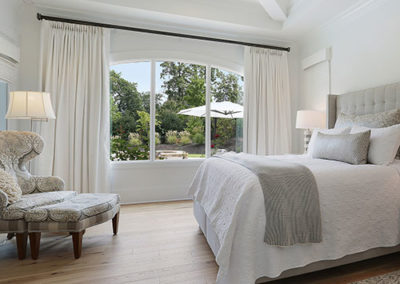 white floor to ceiling motorized drapery in bedroom with white and tan accents