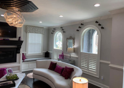 half window white wood shutters on arched living room windows