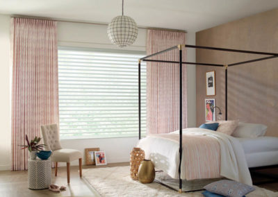 pink floor to ceiling drapery in bedroom with tan and white accents