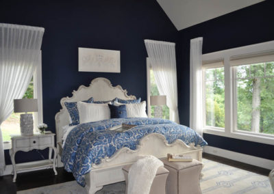 White light filtering roller shade on bedroom windows with navy and blue accents on walls